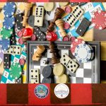 A checkerboard with a myriad of game board pieces, including dice, chips, and chess pieces.