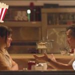 A photo of a young woman and an older man in a diner.